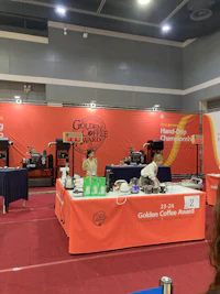 a woman standing in front of a table at a convention