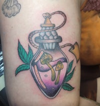 a tattoo of a bottle with a flower in it