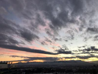 a sunset over a city with mountains in the background