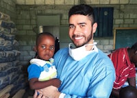 a man holding a child in front of a building