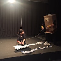 a man and a woman on a stage with a cardboard box