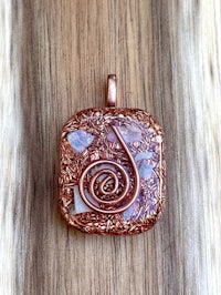a copper pendant with a spiral design on it