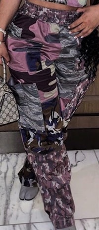 a woman posing in a purple and black outfit