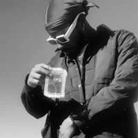 a black and white photo of a man holding a cell phone