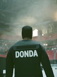 the back of a man in a black jacket with the word donda on it