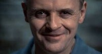 a man smiling in a blue shirt