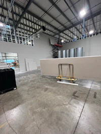 a large warehouse with a large white table in the middle