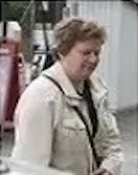 a woman in a white jacket standing next to a car