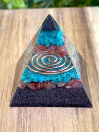 a blue and turquoise pyramid on a wooden table