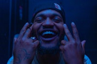 a man with tattoos is making a gesture with his hands