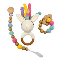 a crocheted unicorn rattle with wooden beads and a wooden ring