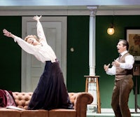 a man and woman standing on a couch in a green room
