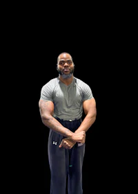 a man posing with his arms crossed in front of a black background