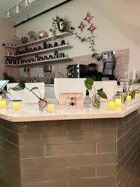 a counter with candles and plants on it