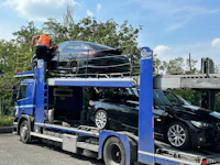 a man loading a car onto a flatbed truck