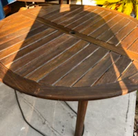 a round wooden table on a patio