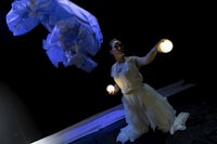 a woman in a white dress is holding a white ball