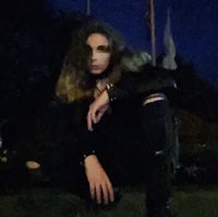 a woman crouching on the grass at night