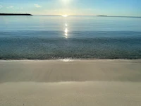 a panoramic view of a beach with the sun shining on it