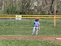 a young boy is playing baseball on a field