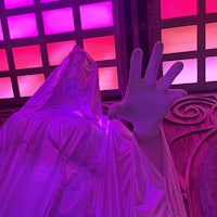 a mannequin in a purple cloak with a hand out