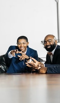 three business men posing for a picture at a conference table