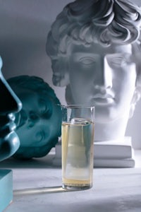 a glass of water next to a statue