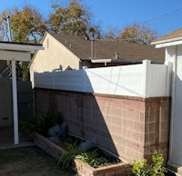 a small backyard with a white fence