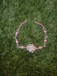a pink flower headband laying on the grass