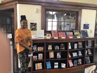 a woman standing in front of a bookshelf in a library