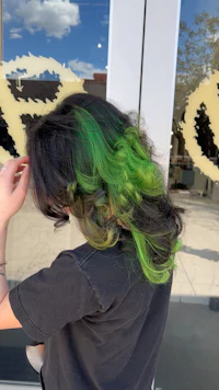 a woman with green hair in front of a store