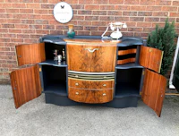 a wooden bar cabinet with drawers and doors
