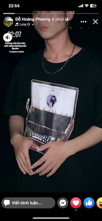 a picture of a man holding a t - shirt with a picture of a book on it