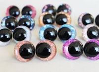 a set of black and pink glitter eye stud earrings