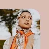a woman wearing a scarf in a field