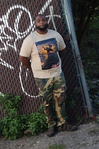 a man standing in front of a fence