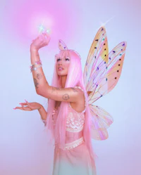 a woman in a pink fairy costume holding a light
