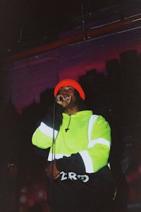 a man in a neon jacket singing into a microphone