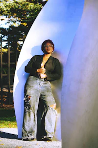 a woman leaning against a white sculpture