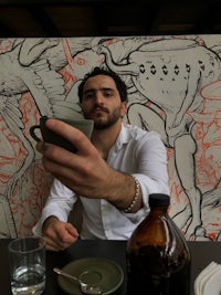 a man is taking a picture of a cup of coffee