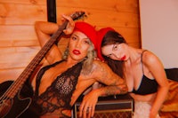 two women posing for a photo with a guitar