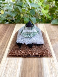 a pyramid with sand and rocks on a wooden table