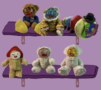 a group of stuffed animals on a purple shelf