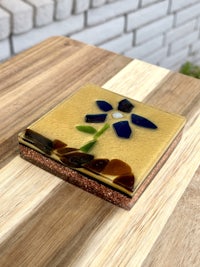 a glass coaster with a flower on it