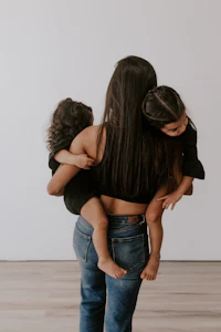 a woman is holding her two children in her arms