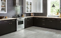a kitchen with black and white cabinets and a stove