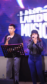 two people standing in front of a microphone