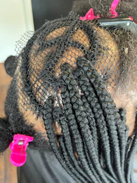 a woman's hair with braids and clips on it