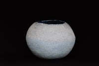 a blue and white vase on a black background