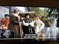 a tv screen showing a group of women dressed in renaissance costumes